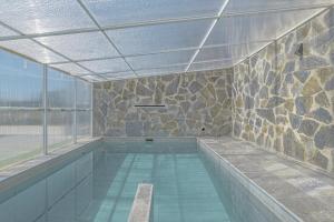 a indoor swimming pool with a stone wall at Casa El Elefante in La Muela