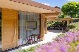 a house with glass doors and a table and chairs at Albchalet in Rosenfeld