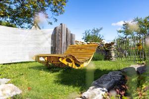 a yellow bench sitting in the grass near a fence at Albchalet in Rosenfeld