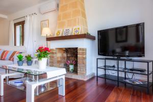 a living room with a television and a fireplace at Can Domingo in Pollença