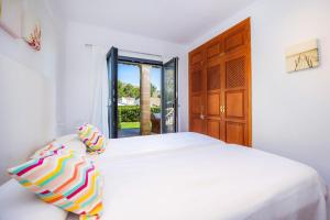 a white bedroom with a bed and a window at Can Domingo in Pollença +28 photos