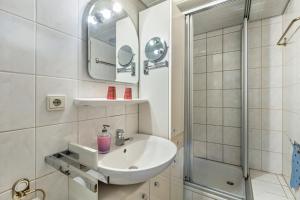 a white bathroom with a sink and a shower at Feriewohnung Hirtenhaus in Attendorn +16 photos