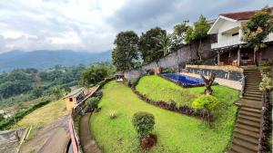 a house on top of a hill with a yard at Villa Kay Height in Kopo 2