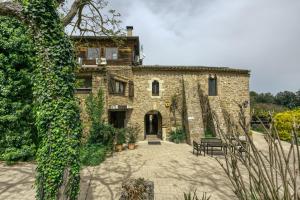 a stone house with a bench in front of it at Casa Rural Mas Fuselles in Girona