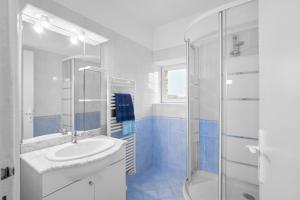 a blue and white bathroom with a sink and a shower at Gite La Bessede - Dordogne in La Chapelle-Aubareil