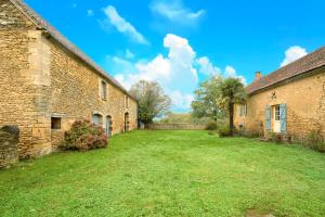 an empty yard between two brick buildings at Gite La Bessede - Dordogne in La Chapelle-Aubareil