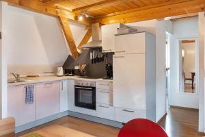 a kitchen with white appliances and wooden ceilings at Ferien im Fachwerk in Bermatingen