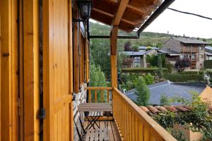 a wooden balcony with a bench on a house at Chalet de montaña con vistas in Prullans