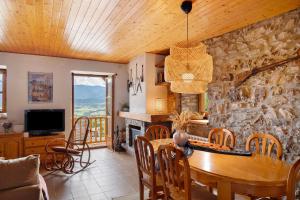 a dining room with a table and a stone wall at Chalet de montaña con vistas in Prullans