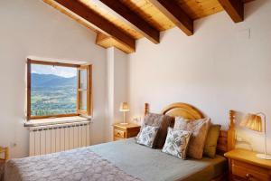 a bedroom with a bed with a large window at Chalet de montaña con vistas in Prullans