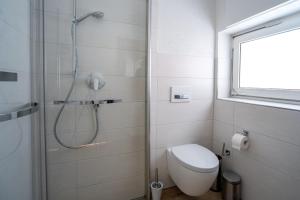 a white bathroom with a shower and a toilet at Ferienwohnung Agnes in Rheinfelden +19 photos