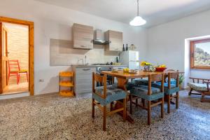 a kitchen with a wooden table and chairs in a room at Casa Sonia in Osilo