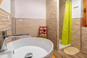 a bathroom with a sink and a green shower curtain at Casa Sonia in Osilo