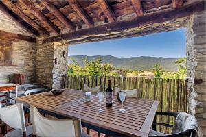 a wooden table with a bottle of wine on a balcony at Regalate Paz in Estallo