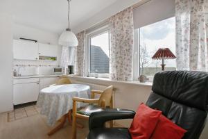 a kitchen with a table and a chair and a window at Haus Halligblick in Dagebüll