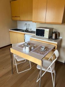 a small kitchen with a table and a microwave at Ninette, intimità e natura in Sauze di Cesana