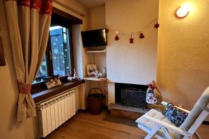 a living room with a fireplace and a window at Ninette, intimità e natura in Sauze di Cesana
