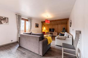 a living room with a couch and a chair at Chalet les églantiers in Valloire