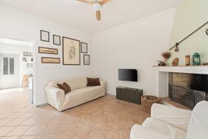 a living room with a couch and a fireplace at I Tre Nuraghi in Tresnuraghes