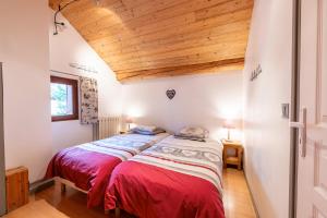 a bedroom with two beds and a wooden ceiling at Chalet les églantiers in Valloire