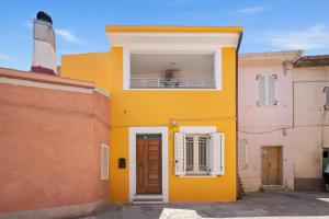 a yellow house with a window and a door at I Tre Nuraghi in Tresnuraghes