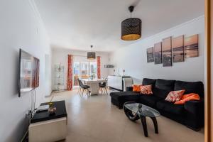 a living room with a black couch and a table at Casa d' Ana in Sesimbra