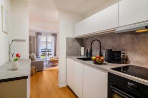 a kitchen with white cabinets and a bowl of fruit on the counter at Ferienapartment Olivia in Bodman-Ludwigshafen