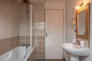 a bathroom with a sink and a bath tub and a mirror at Gite La Sabaudia in Gérardmer +23 photos