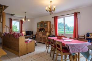 a dining room with a red table and chairs at Gite La Sabaudia in Gérardmer