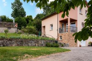 a large pink house with a stone wall at Gite La Sabaudia in Gérardmer
