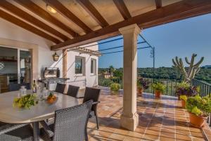 an outdoor patio with a table and chairs and a grill at Algueret in Portopetro