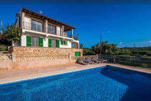 a house with a swimming pool in front of a house at Algueret in Portopetro