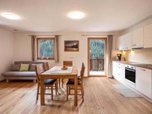 a kitchen and dining room with a table and chairs at Pfattenspitz Maurerhof in Valdurna