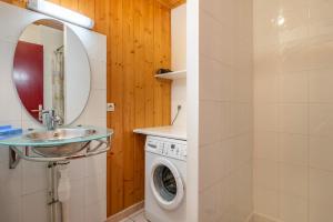 a bathroom with a washing machine and a sink at Chartrousin in Saint-Hilaire