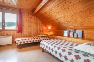 a bedroom with two beds in a wooden cabin at Chartrousin in Saint-Hilaire
