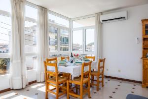 a dining room with a table and chairs and windows at Apartamento Socorro 39-1 in Felanitx