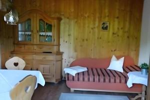 a bedroom with a red bed and a wooden wall at Ferienwohnung Zugspitze in Grainau