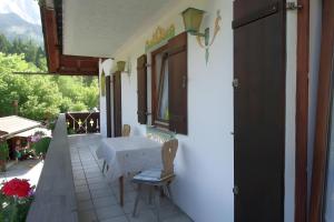 a balcony of a house with a table and chairs at Ferienwohnung Zugspitze in Grainau