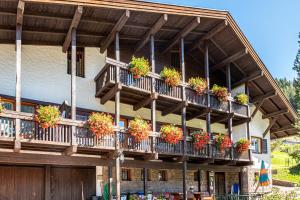a building with lots of potted plants on the balconies at Cesa Soramurat Appartamento 4 in Canazei