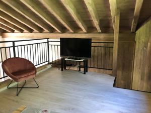 a living room with a television and a chair at Chalet L'envers in Champagny-en-Vanoise