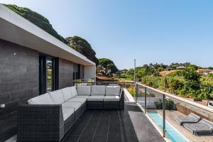 a couch on the balcony of a house at Casa Praia do Meco in Sesimbra