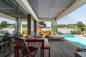 a dining room with a table and a swimming pool at Casa Praia do Meco in Sesimbra