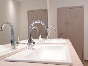 a bathroom with two sinks and two faucets at Ferienwohnung Am Lennepark in Schmallenberg +8 photos