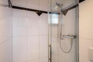 a bathroom with a shower with a glass door at Seeblick in Immenstaad am Bodensee +12 photos