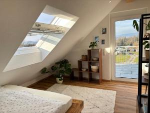 a attic bedroom with a bed and a large window at Ferienwohnungen Am Winkelhof in Deggenhausertal +68 photos
