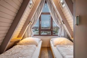 two beds in a room with a window at Seeblick in Immenstaad am Bodensee