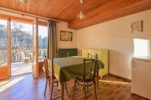 a dining room with a table and a balcony at Chalet Paisible in Bourg-Saint-Maurice