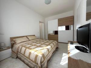 a bedroom with a bed and a flat screen tv at Domus Teresa in Capoterra