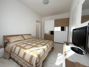 a bedroom with a bed and a flat screen tv at Domus Teresa in Capoterra
