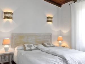 a white bedroom with two beds and two lamps at Villa Bua in Costa Rei +18 photos